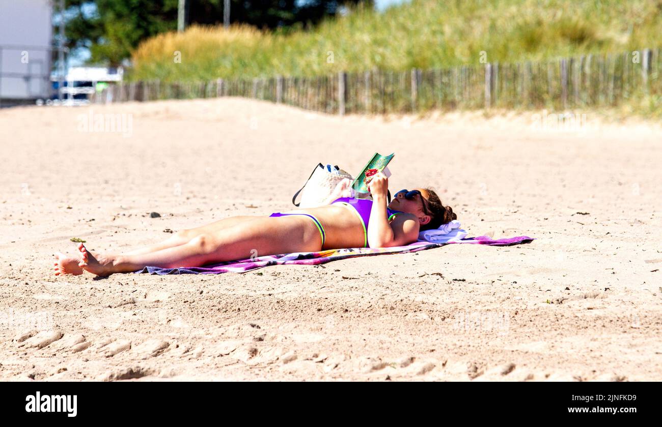 Dundee, Tayside, Scotland, UK. 11th Aug, 2022. UK weather: Extremely hot August temperatures in North East Scotland reached 28°C. Visitors swarm to Broughty Ferry beach in Dundee to enjoy the warm, wonderful summer weather and sunbathe on the sand. Credit: Dundee Photographics/Alamy Live News Stock Photo