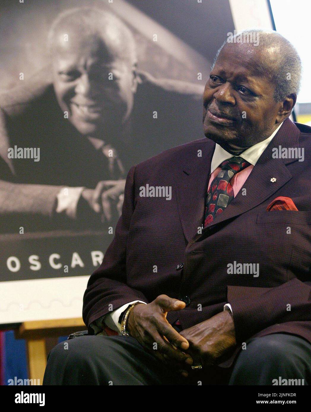Canadian jazz pianist Oscar Peterson smiles while being honoured by Canada Post on his 80th birthday with his picture on a Canadian stamp in Toronto on August 15, 2005. The Royal Canadian Mint is launching a special coin celebrating late music legend Oscar Peterson. The one-dollar circulation coin is set to be unveiled at a Toronto event this morning. THE CANADIAN PRESS/Nathan Denette Stock Photo