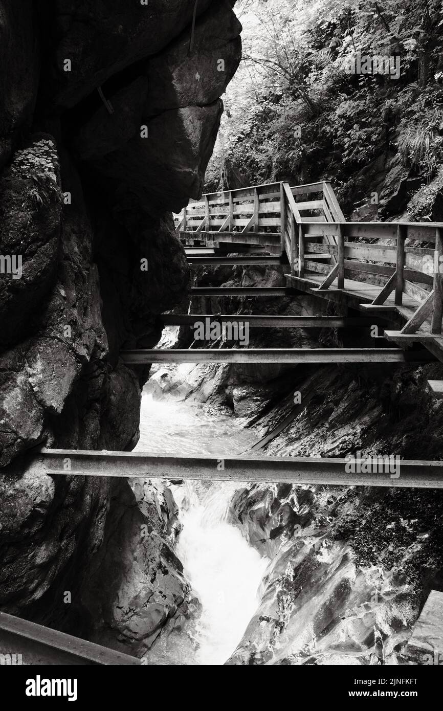 A grayscale shot of a footbridge over the Seisenbergklamm gorge in Weissbach bei Lofer, Austria Stock Photo