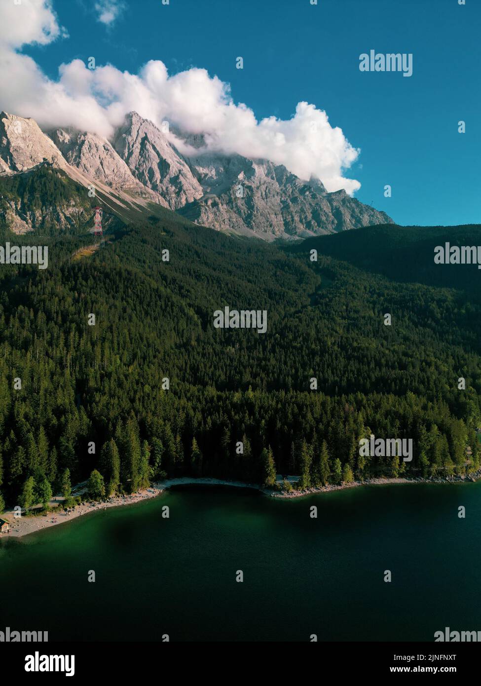 A vertical shot of the green mountains and lake against the background ...