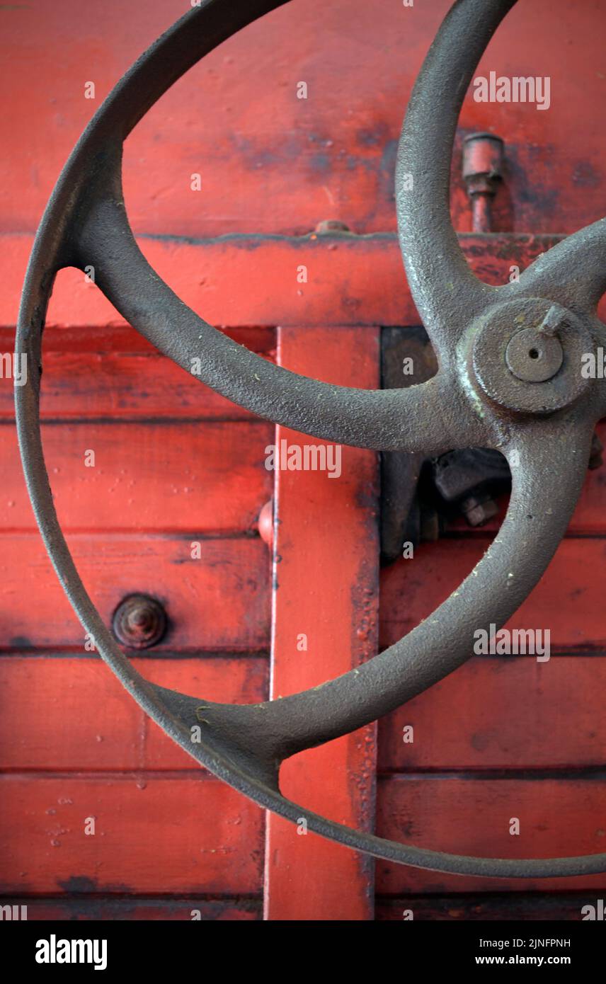 usting weathered metal wheel on vintage farm threshing machine Stock Photo