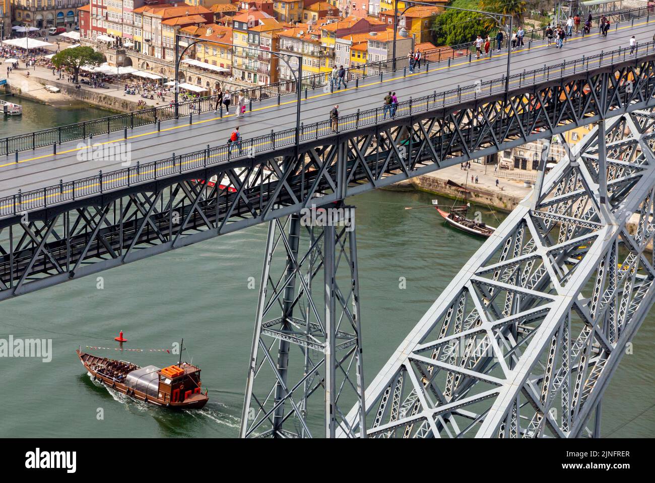Tourist boat sailing on the River Douro in the centre of Porto a major city in northern Portugal with Ponte Dom Luis 1 bridge in foreround Stock Photo