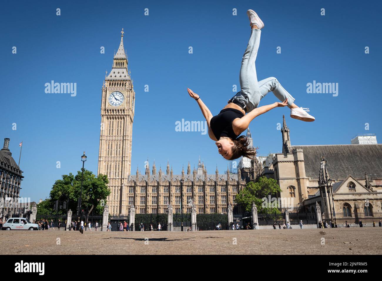 Trampolinist, Nicole Steiner from Switzerland practices some moves on a dried out Parliament Square in central London after competing in the Freestyle Trampoline World Championships in Hackney, east London. The Met Office has issued an amber heat warning running between Thursday and Sunday, which could see temperatures peak at 36C across southern England and eastern Wales, with some areas facing an 'exceptional' risk of wildfires as the Fire Severity Index is raised to its highest level. Picture date: Thursday August 11, 2022. Stock Photo
