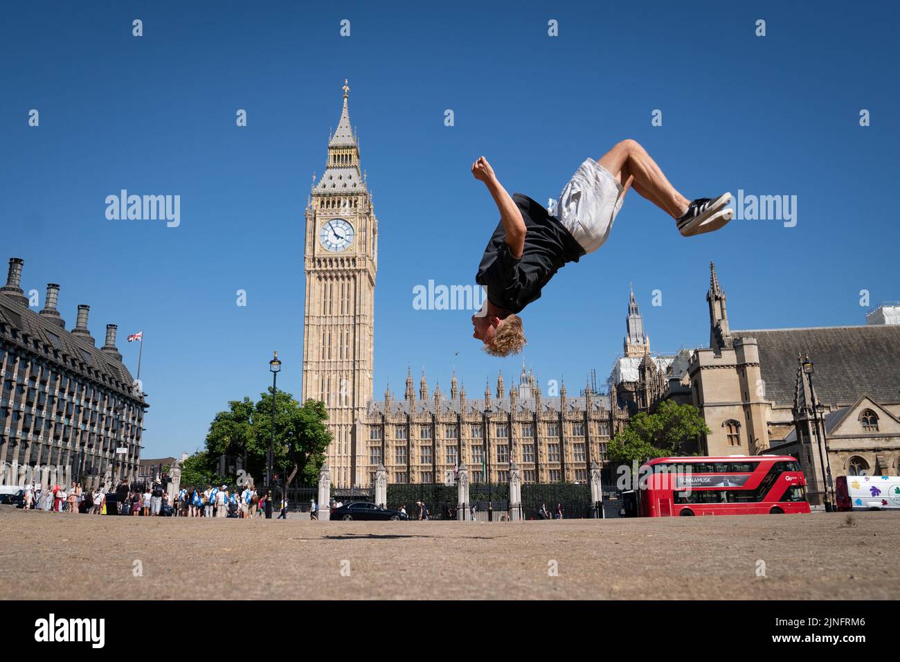Trampolinist, Johannes Luethi from Austria practices some moves on a dried out Parliament Square in central London after competing in the Freestyle Trampoline World Championships in Hackney, east London. The Met Office has issued an amber heat warning running between Thursday and Sunday, which could see temperatures peak at 36C across southern England and eastern Wales, with some areas facing an 'exceptional' risk of wildfires as the Fire Severity Index is raised to its highest level. Picture date: Thursday August 11, 2022. Stock Photo