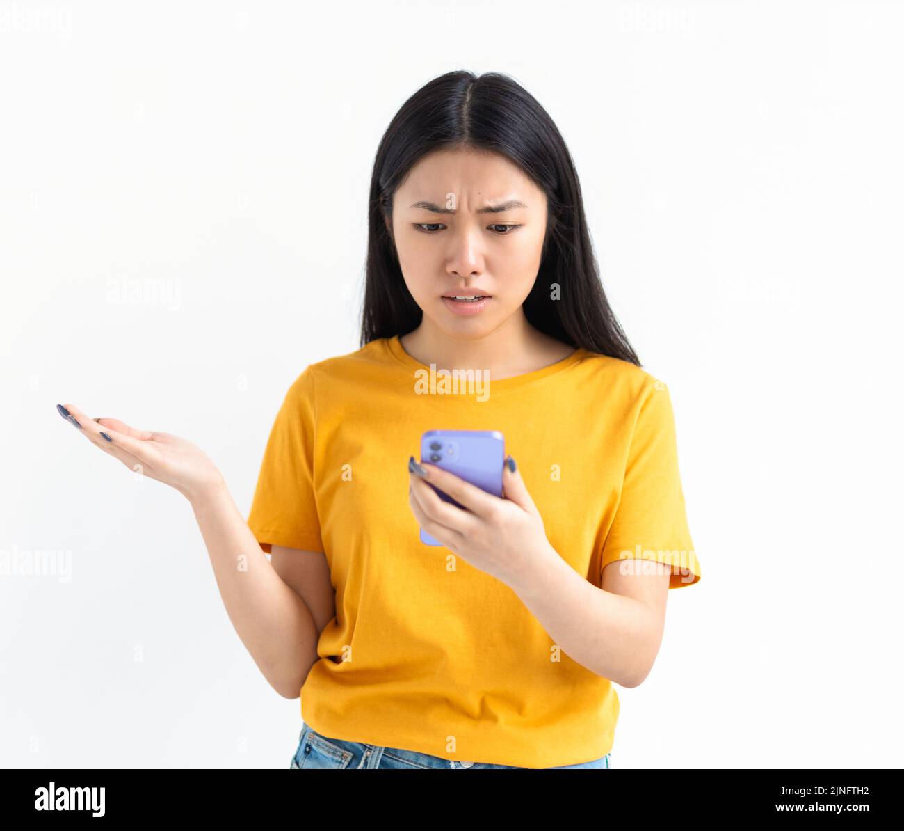 Young woman freelancer looking worried at mobile phone reading bad news on email loss trouble concept Stock Photo