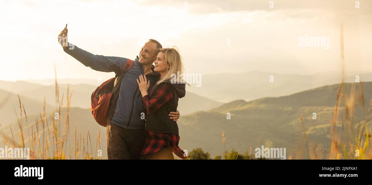 Two hikers relax on top of a mountain with great view Stock Photo - Alamy
