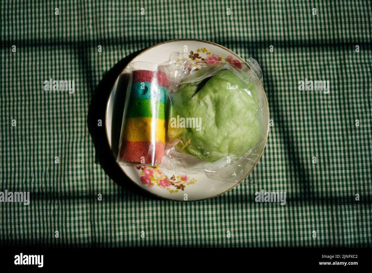 Rainbow roll cake with green boazi  on plate Stock Photo