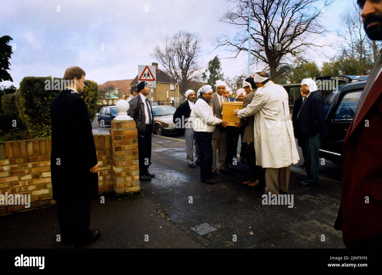 Sikh Funeral (Antam Sanskaar) Men carrying Coffin From Hearse Into Home England Stock Photo