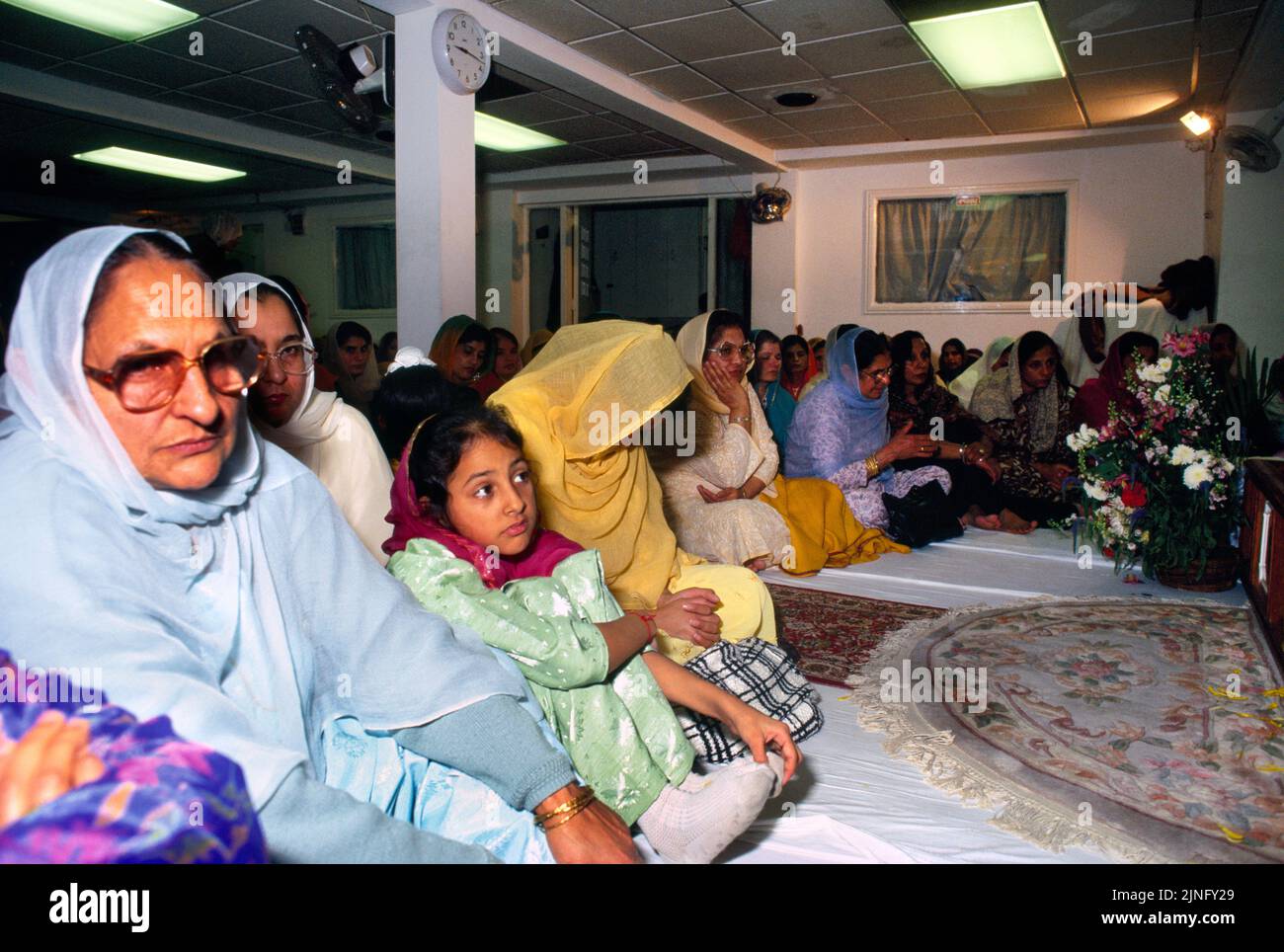 Congregation in Main Hall of Gurdwara Sri Guru Singh Sabha Southall London  England Stock Photo