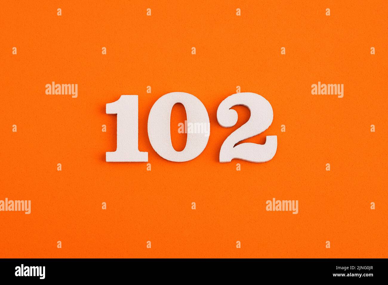 White wooden number 102 on eva rubber orange background Stock Photo - Alamy