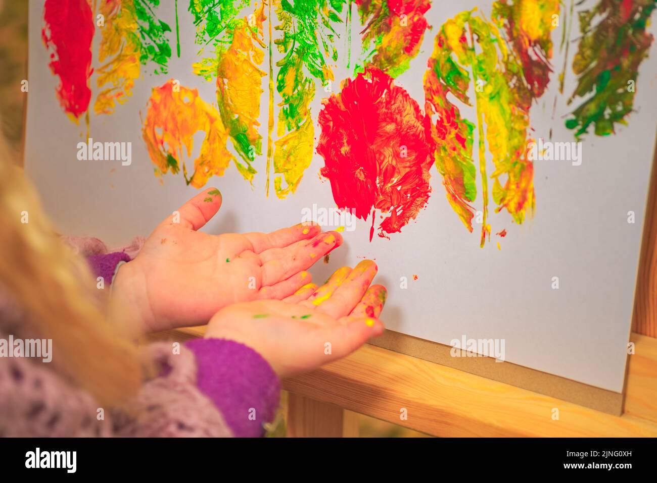 little girl artist with paints in her hands in autumn in the park draws ...