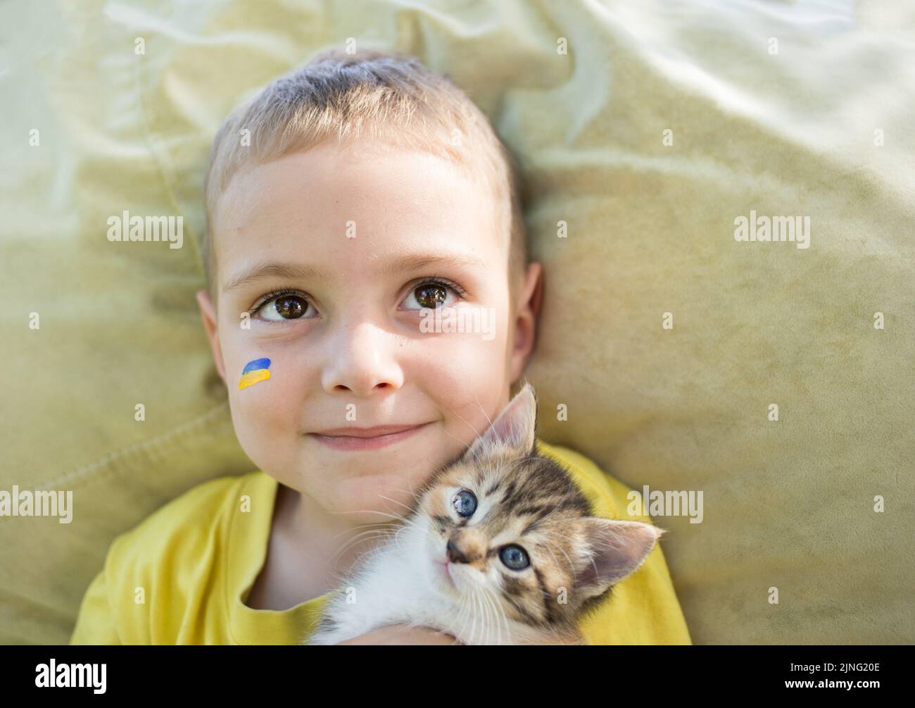 closeup of the face of a 3yearold boy with a painted flag of Ukraine