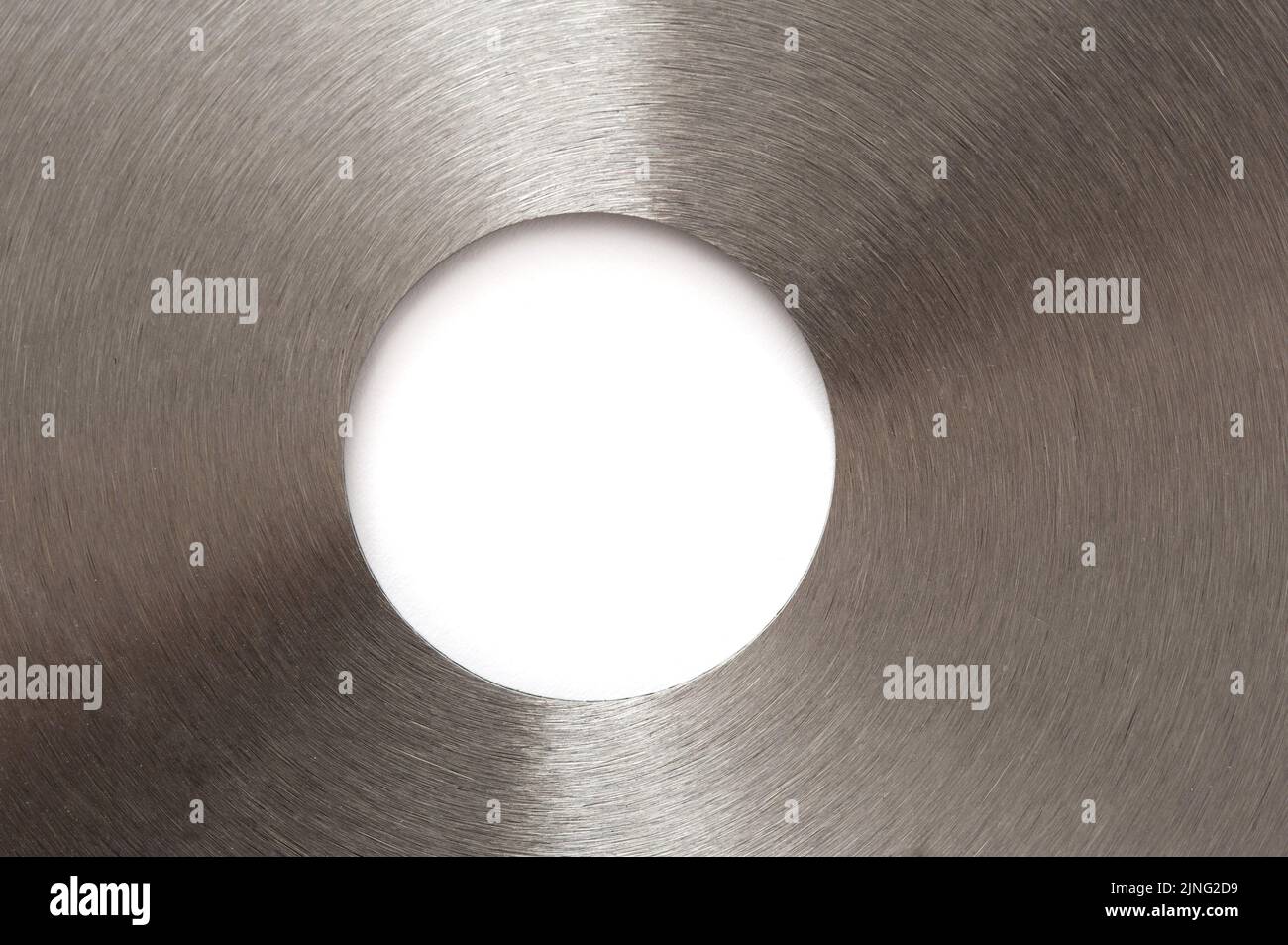 A close up of a metal, stainless steel saw blade and center circle with white copy space in the middle. Stock Photo
