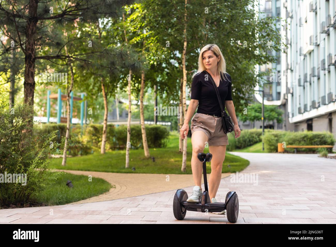 Beautiful woman stand near segway or hoverboard. self balancing