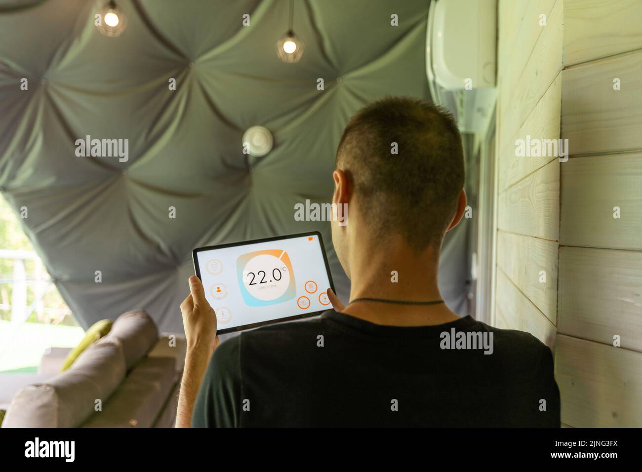 Smart home control on tablet. Interior of living room in the background Stock Photo