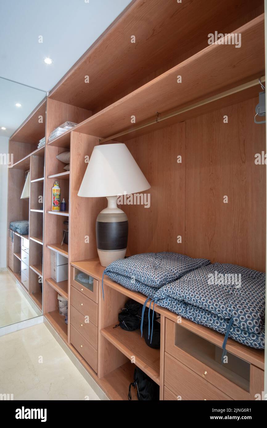 modern wardrobe with clothes hanging on the rail, white wooden wardrobe