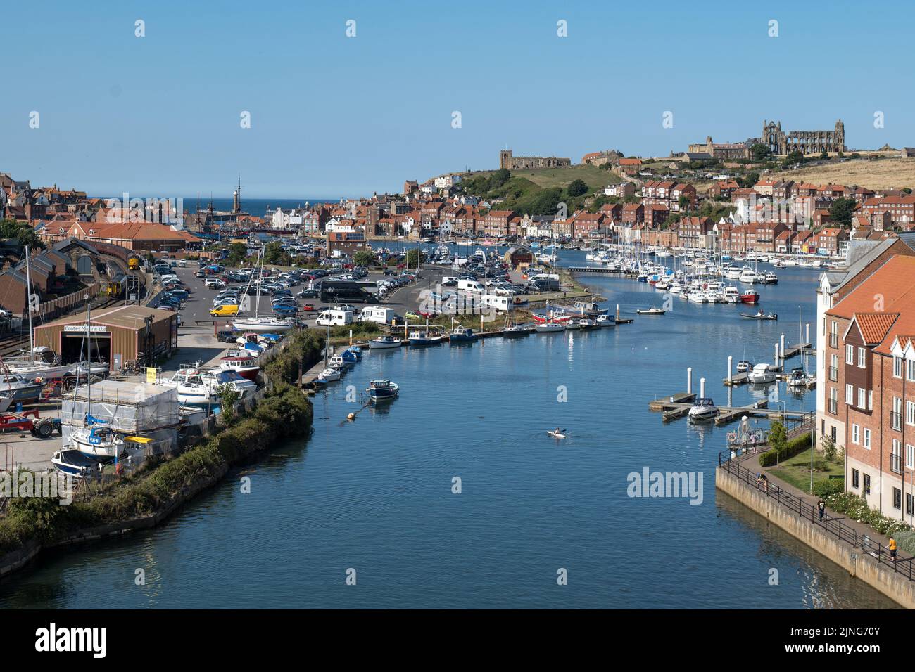 A kayaker is paddling towards Whitby Abbey from the River Esk towards the Whitby Bay and sea as North Yorkshire bathes in the sunshine of the heatwave. North Yorkshire, UK. 11th August, 2022. Stock Photo