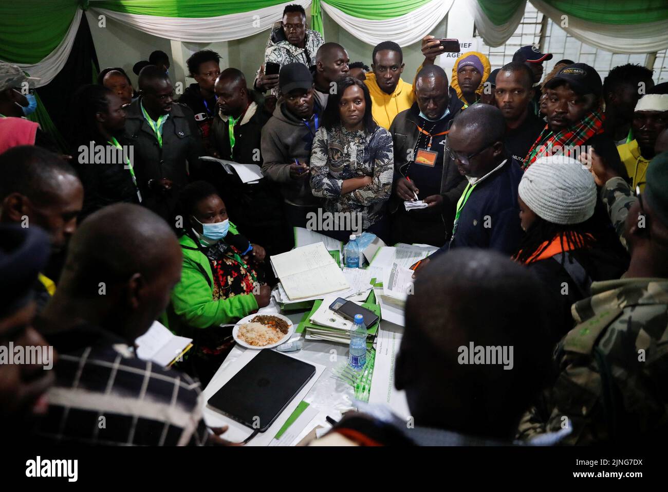 Officials from the Independent Electoral and Boundaries Commission (IEBC) are surrounded by political candidates from various parties and their agents after the general election, at the St. Teresa Girls Secondary School tallying centre near Mathare in Nairobi, Kenya August 11, 2022. REUTERS/Thomas Mukoya Stock Photo