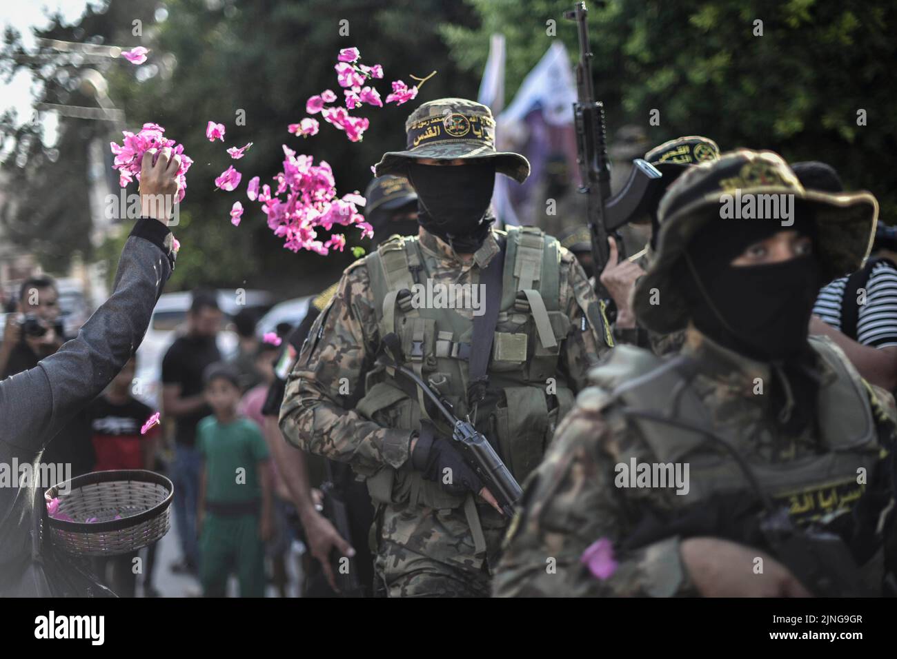 Gaza, Palestine. 10th Aug, 2022. Women sprinkle roses on fighters of