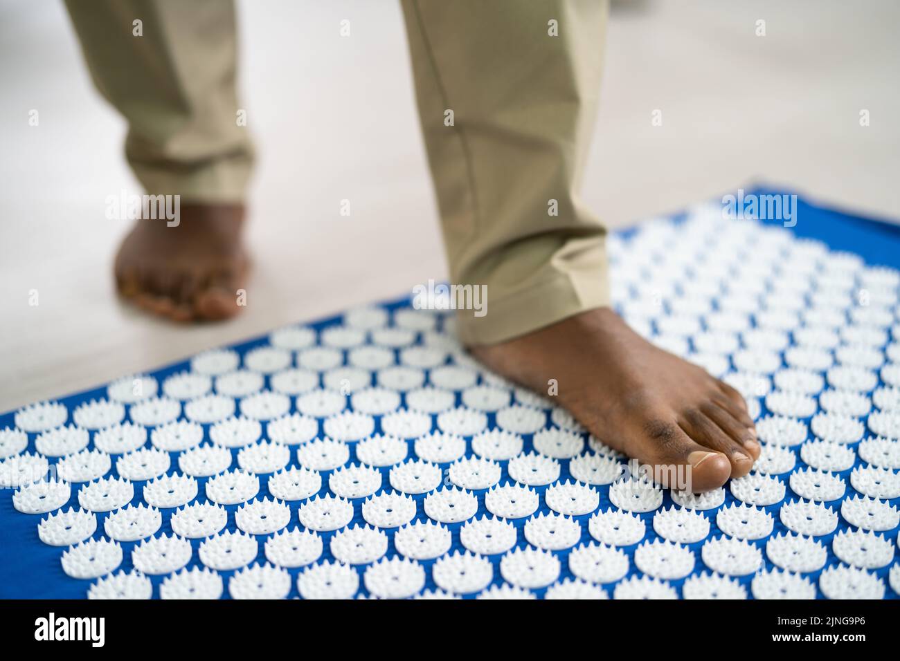 Acupressure Mat And Acupuncture Body Care Equipment. Male Feet Stock