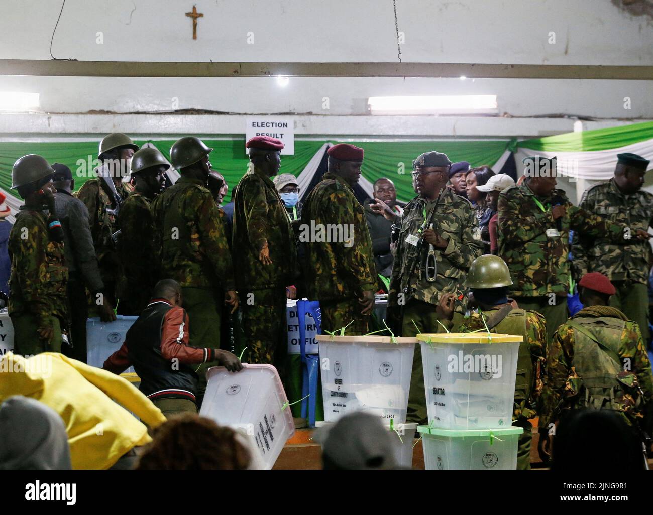Police officers secure the Independent Electoral and Boundaries Commission (IEBC) officials from rowdy agents after the general election, at the St. Teresa Girls Secondary School tallying centre near Mathare in Nairobi, Kenya August 11, 2022. REUTERS/Thomas Mukoya Stock Photo