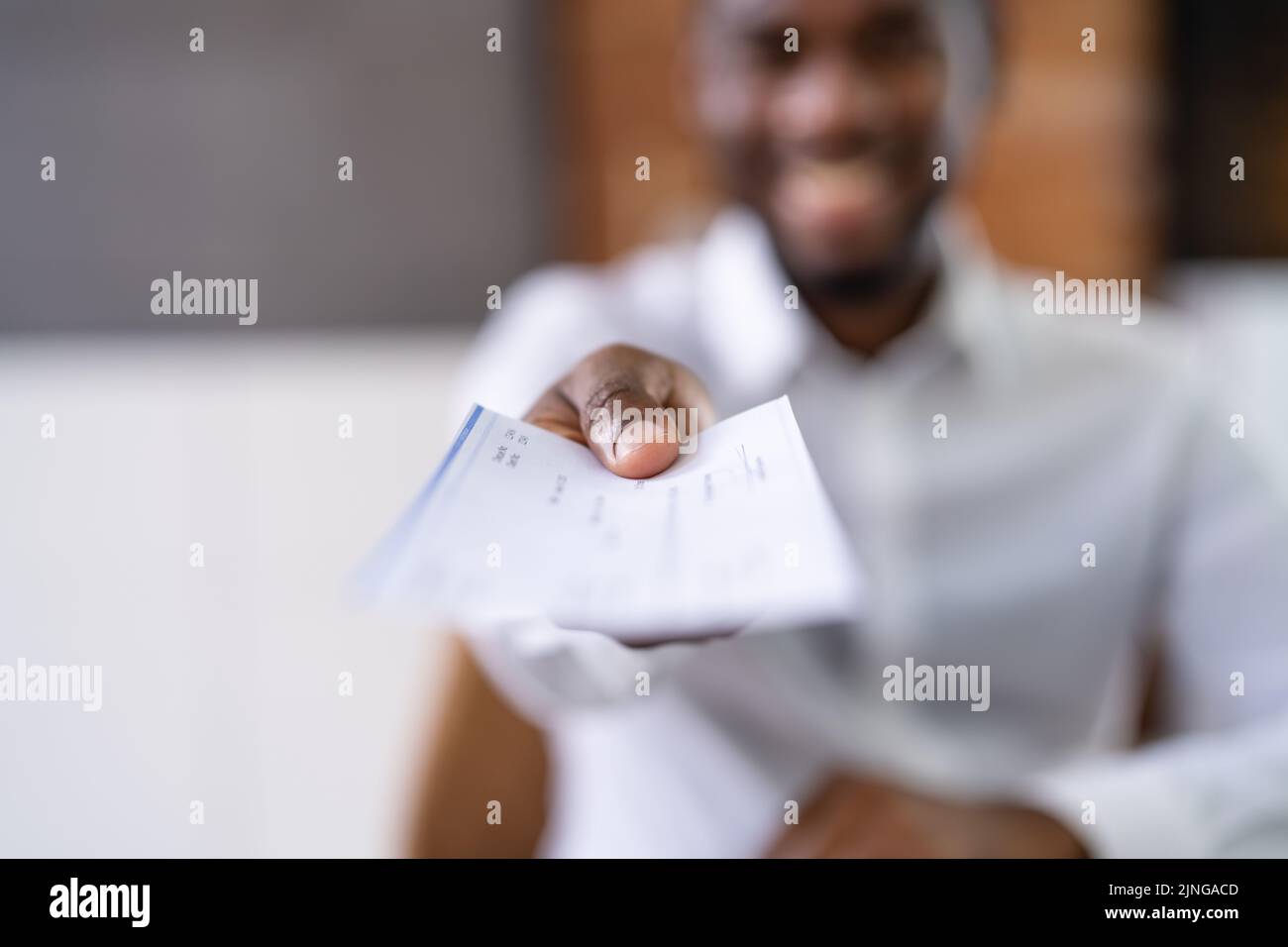 African Business Man Giving Paycheck Or Payroll Cheque Stock Photo