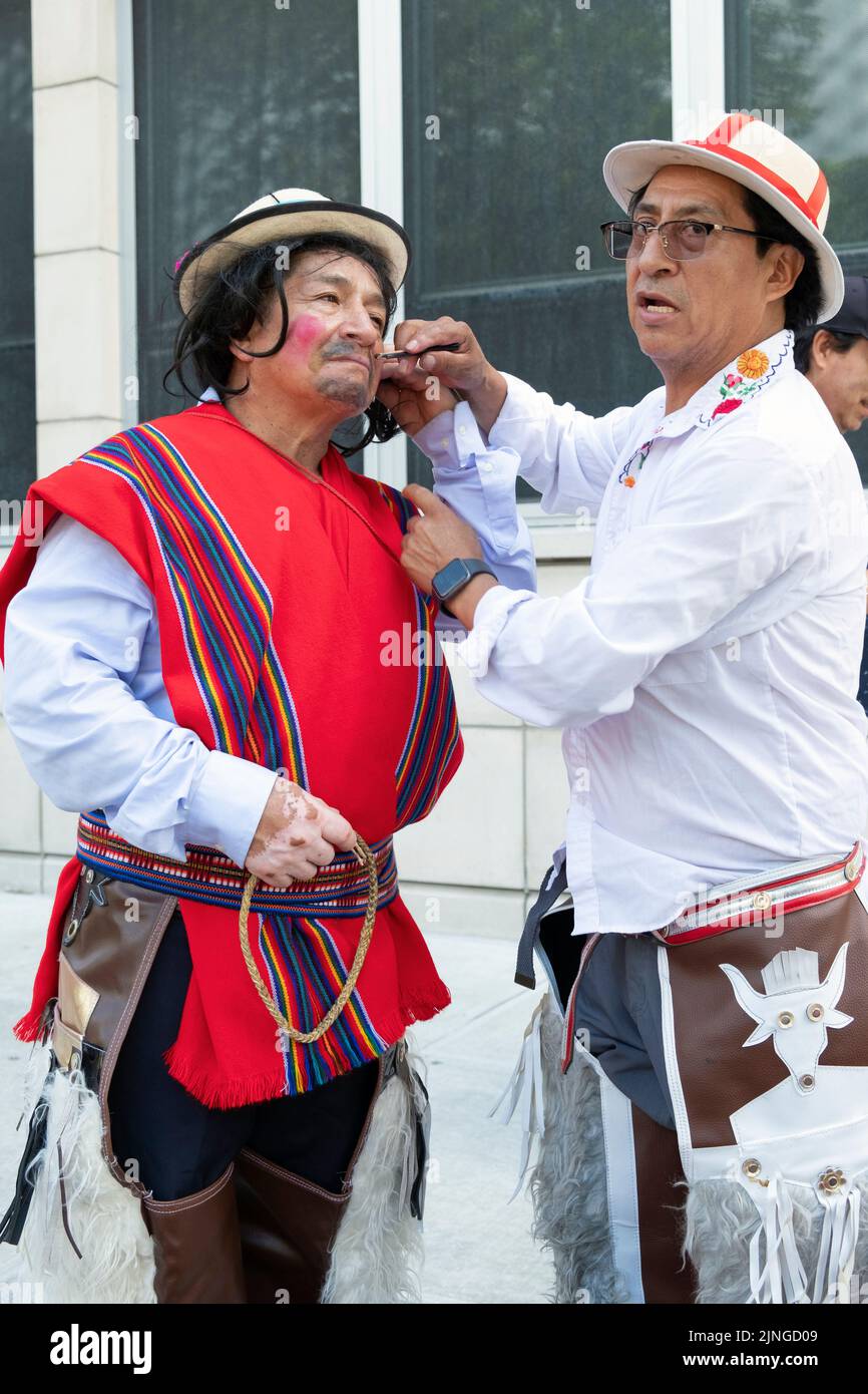 A middle age Ecuadorian clown gets his makeup applied prior to the Ecuadorian Parade NYC 2022 in Jackson Heights, Queens, New York. Stock Photo