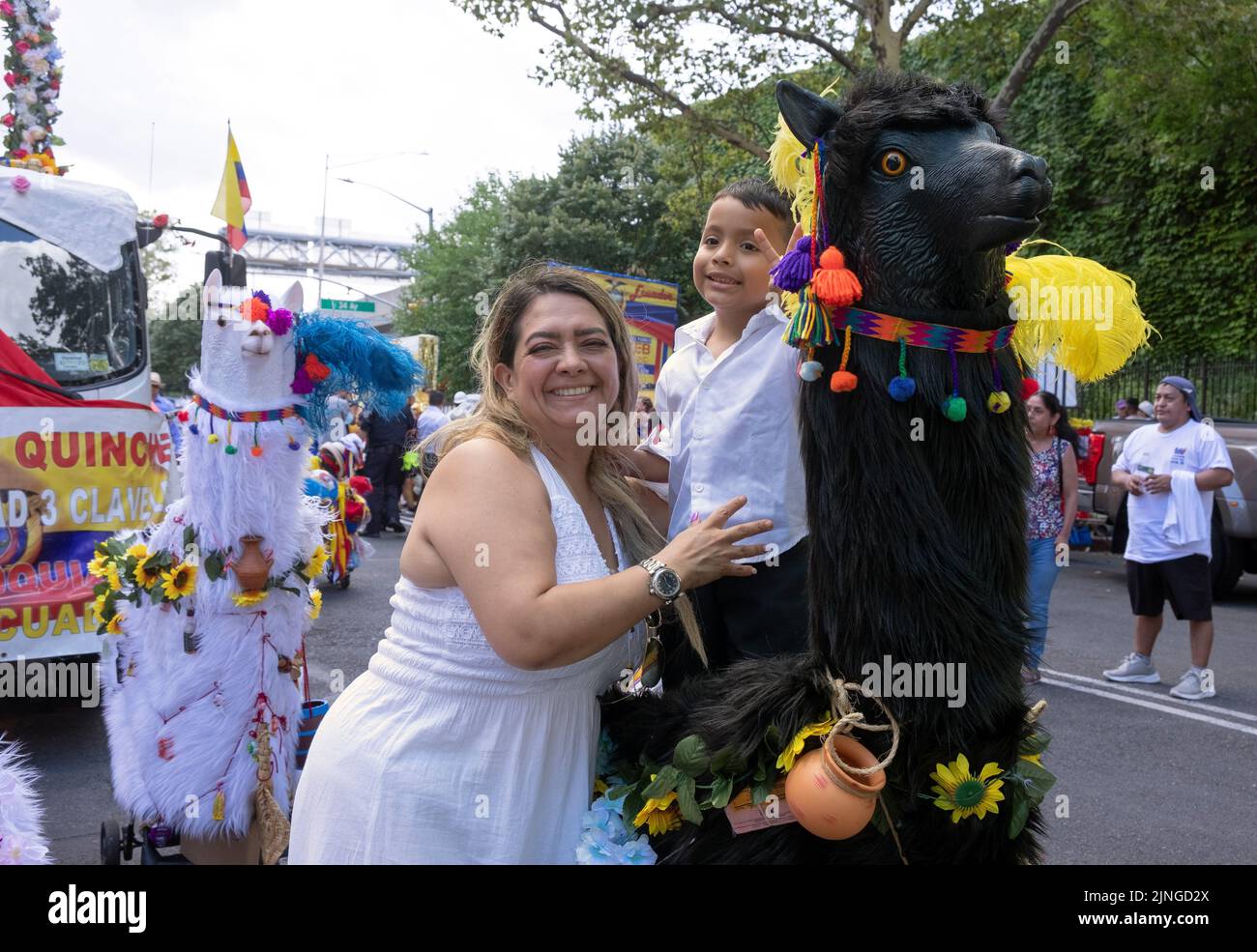 A vendor and her son at a stand with a wooden animal statue. At the