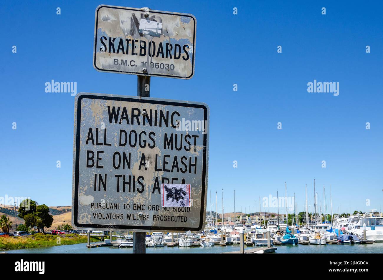 Signs at Benicia Marina in California, USA warn people to keep dogs on a leash and give notice that no skateboards are allowed. Stock Photo