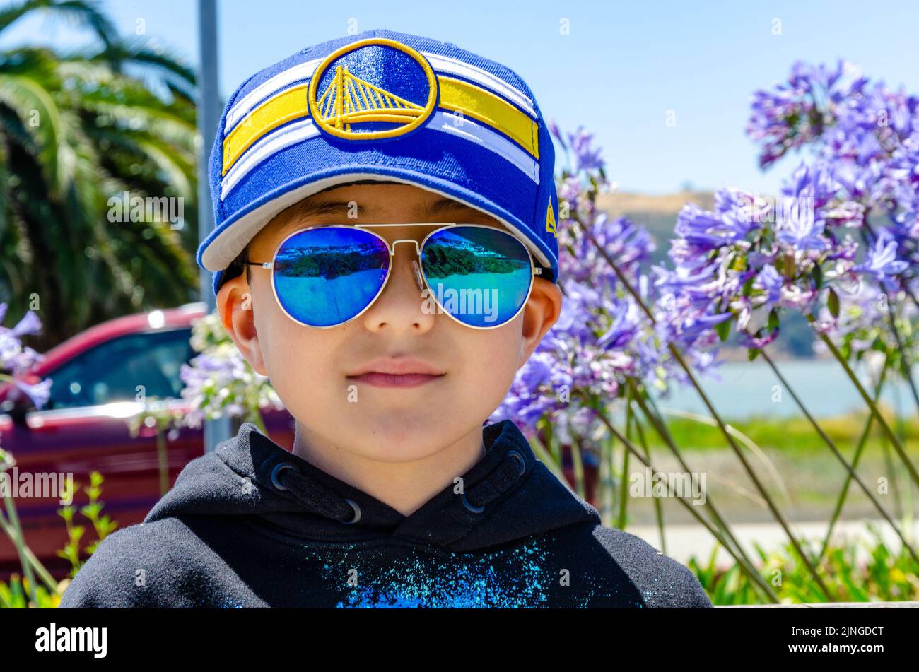 A portrait of a boy wearing reflective sunglasses and baseball cap at Benicia Marina, California, USA Stock Photo