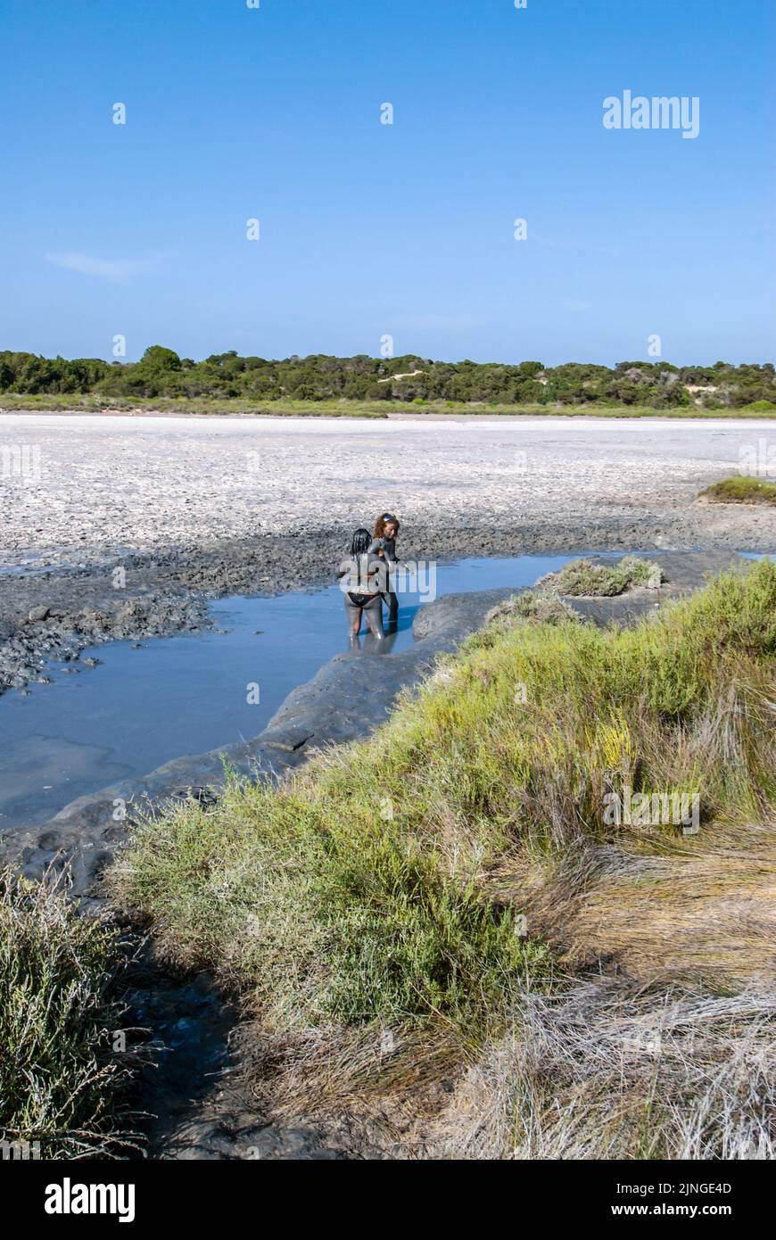 People enjoy a mud bath in Espalmador, a small island located in the