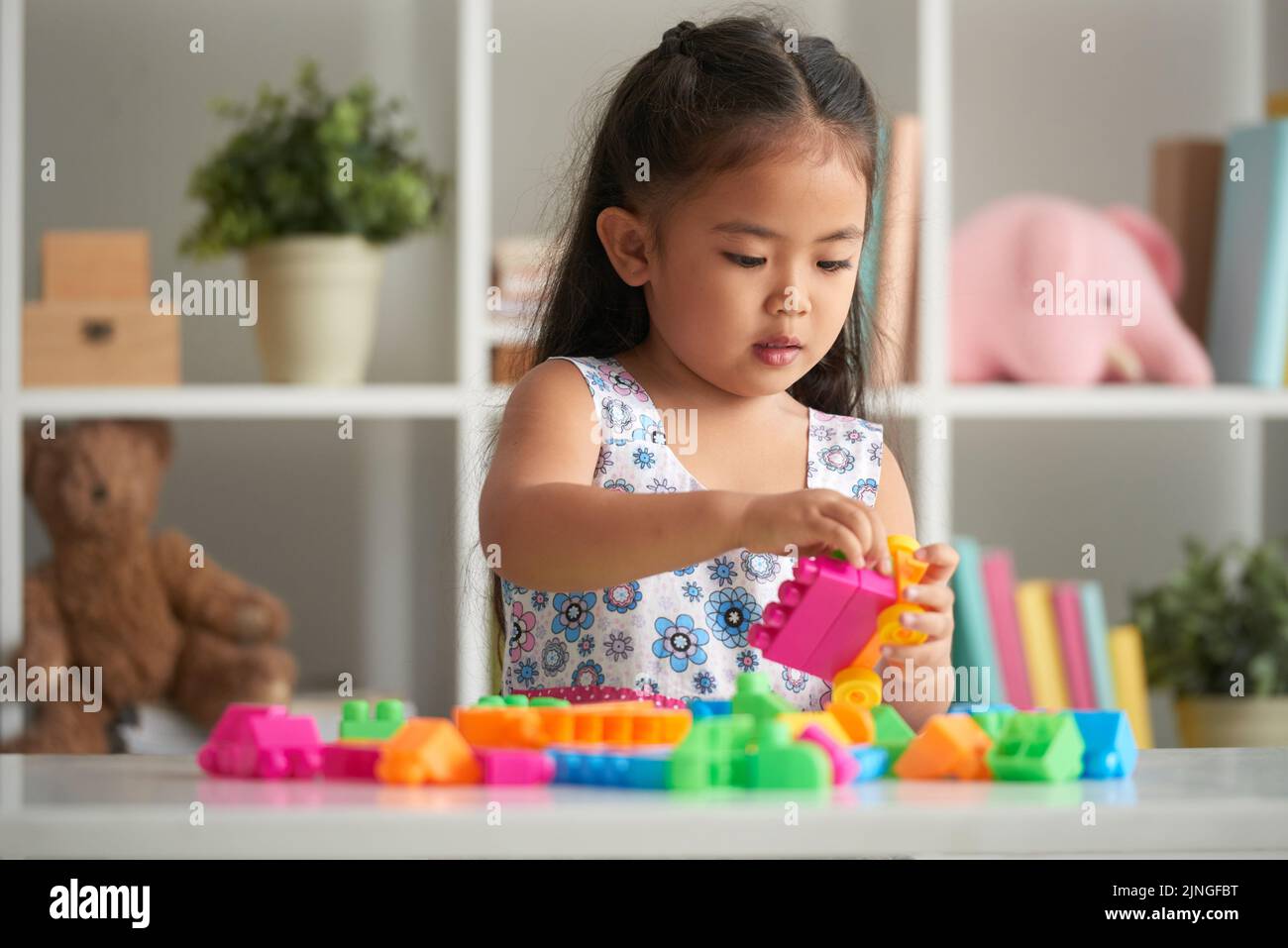 Little girl playing with bright plastic blocks Stock Photo - Alamy
