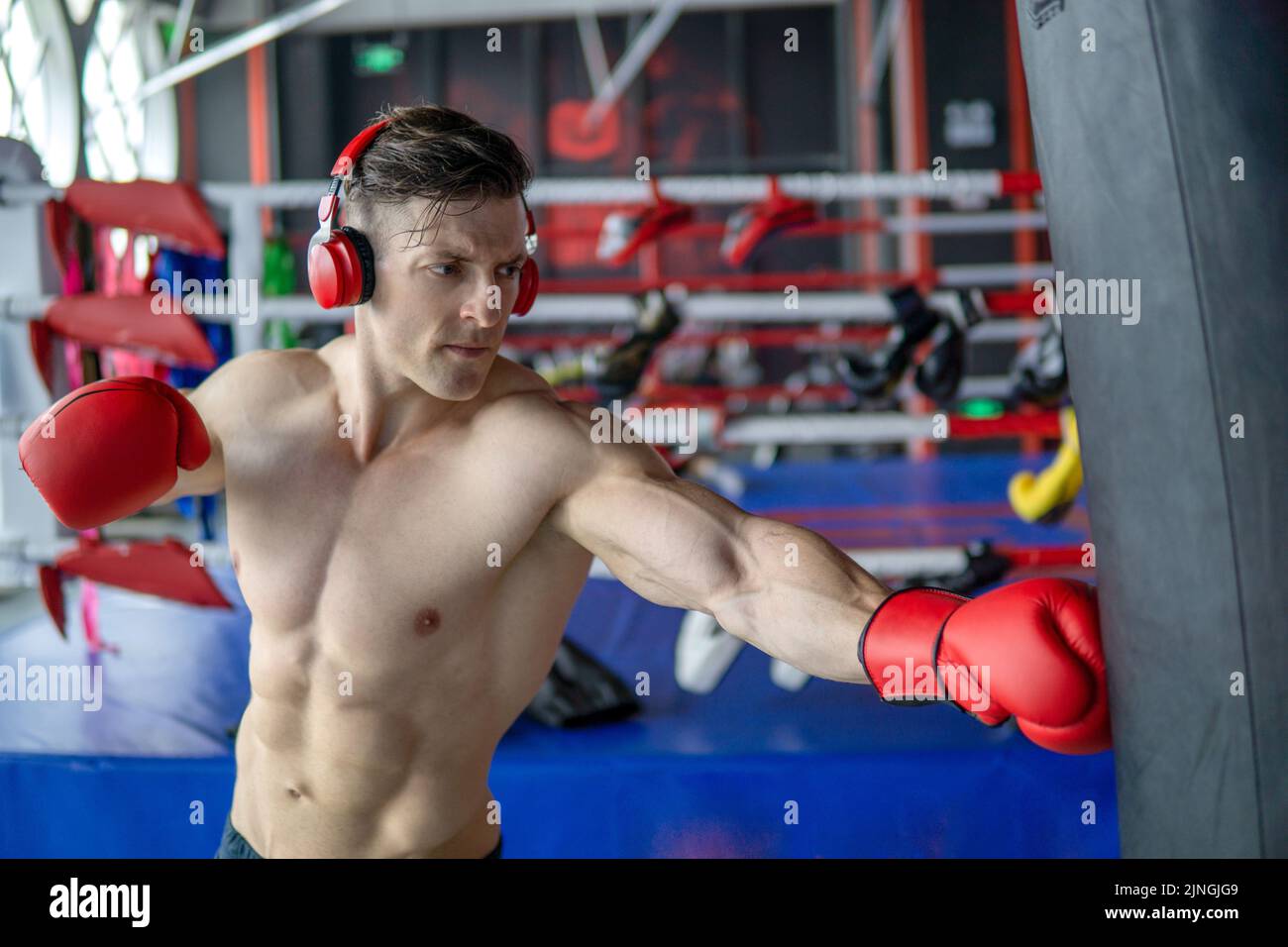 A Caucasian Strong muscular boxer punches the sandbag Stock Photo Alamy