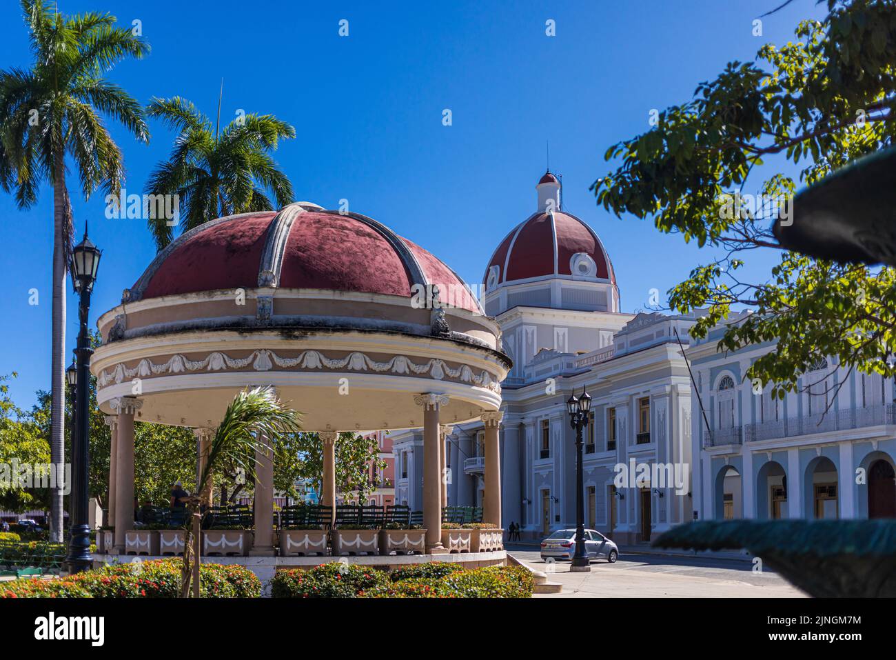 CIENGUEGOS, CUBA - JANUARY 10 2021: Cienfuegos Jose Marti central park with palms and historical buildings, Cienfuegos Province, Cuba Stock Photo