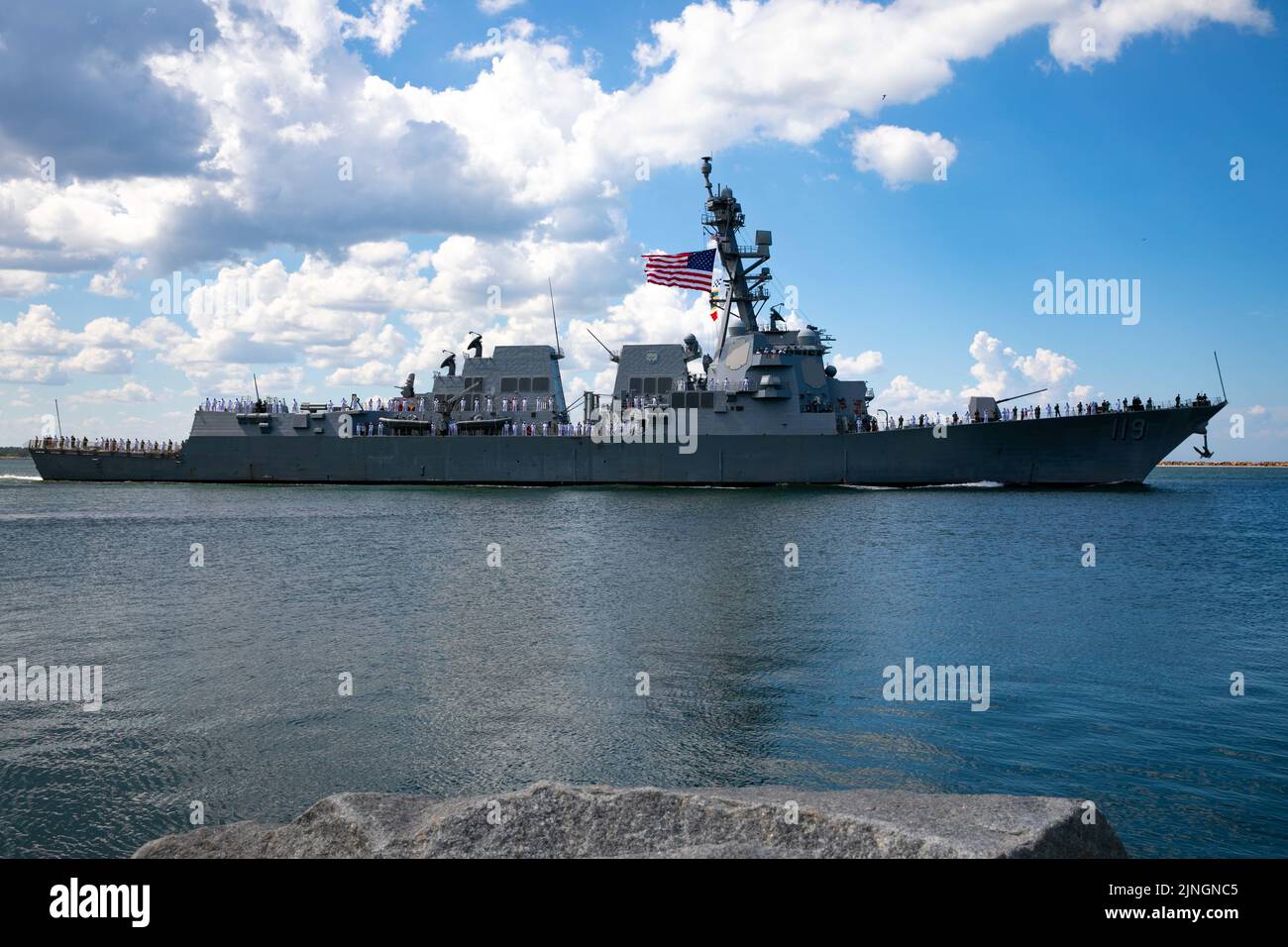 Family members watch as the U.S. Navy Arleigh Burke-class guided-missile destroyer USS Delbert D. Black transits the jetties on the maiden deployment from Naval Station Mayport, August 2, 2022 in Mayport, Florida. Stock Photo