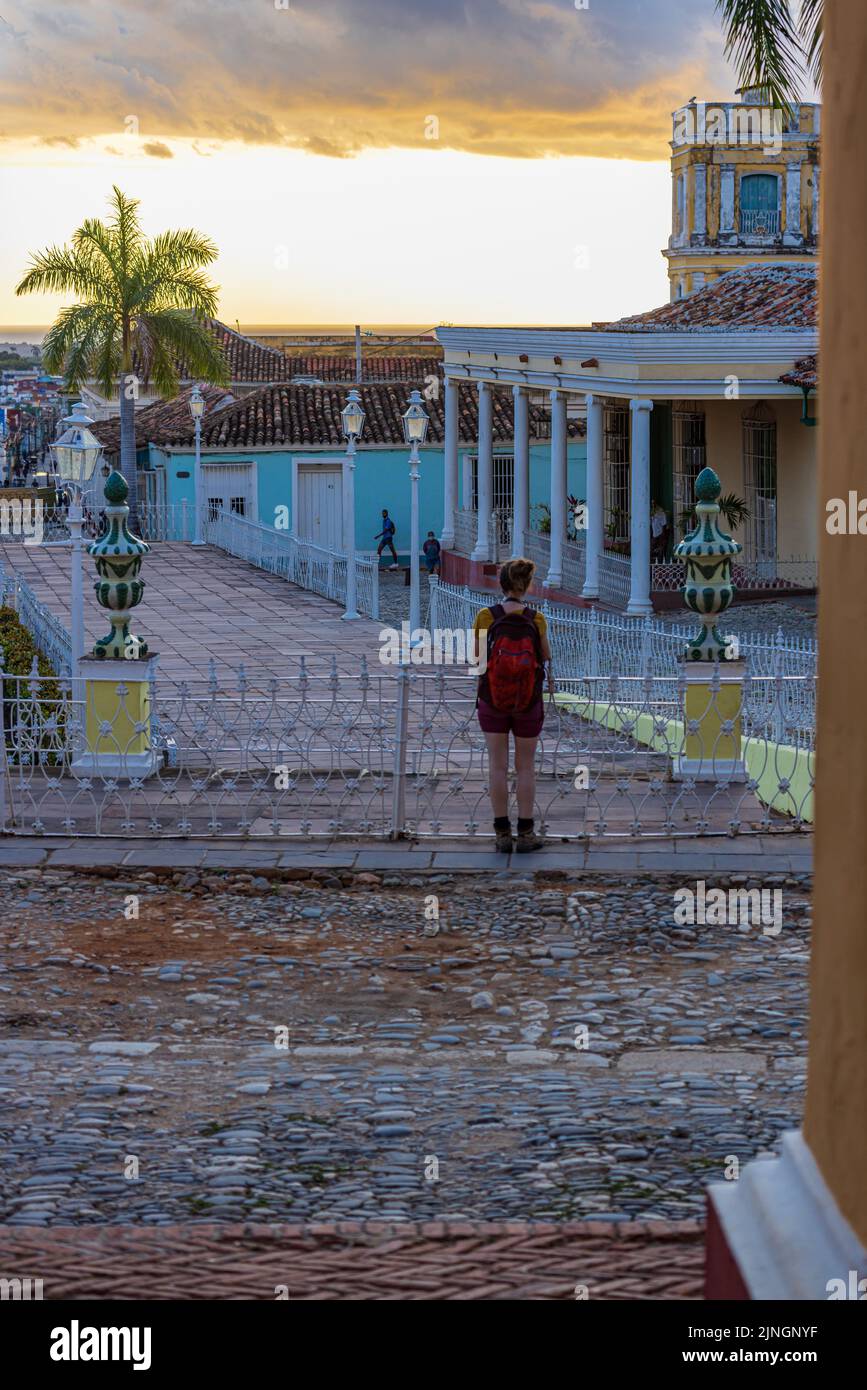 TRINIDAD, CUBA - JANUARY 7, 2021: Female tourist watching sunset on the main square in Trinidad, Cuba Stock Photo
