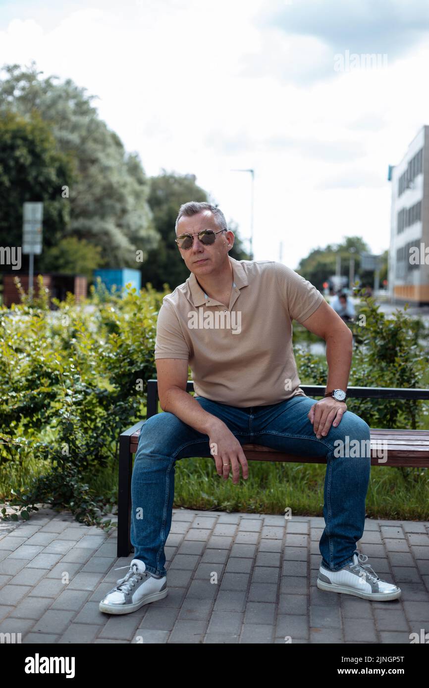 Premium Photo  Young bearded man in sunglasses sitting on a wooden park  bench planning his next chess move