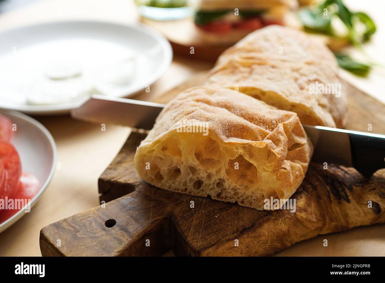 Cutting bread at the table to make sandwiches Stock Photo Alamy