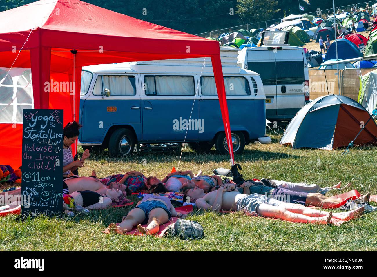 Boomtown, Winchester, UK 11 August 2022 Campers arrive in a heatwave at Boomtown Festival. Seeking water and shade wherever they can find it and heading out on mass as the sun sets. Stock Photo