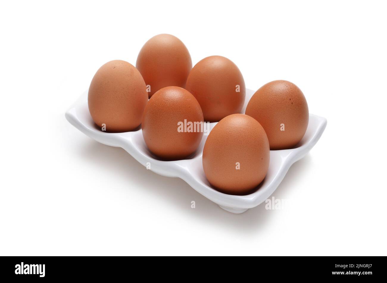 Half a dozen or 6 eggs in white ceramic tray holder isolated on white Stock Photo