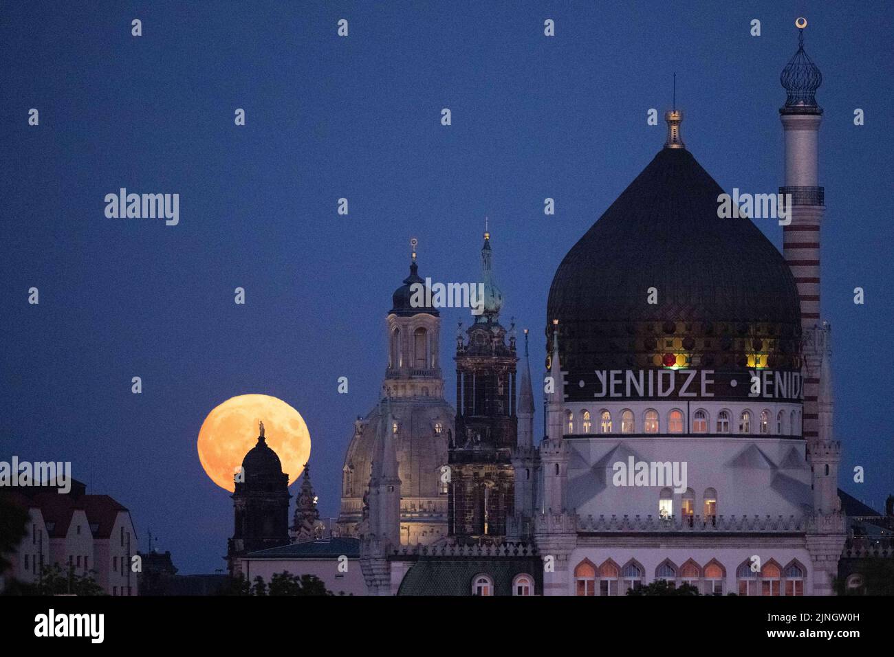 Dresden, Germany. 11th Aug, 2022. The moon rises behind the backdrop of the Ständehaus (l-r), the Frauenkirche, the Catholic Hofkirche, and the former factory building of the Yenidze cigarette factory. Credit: Sebastian Kahnert/dpa/Alamy Live News Stock Photo
