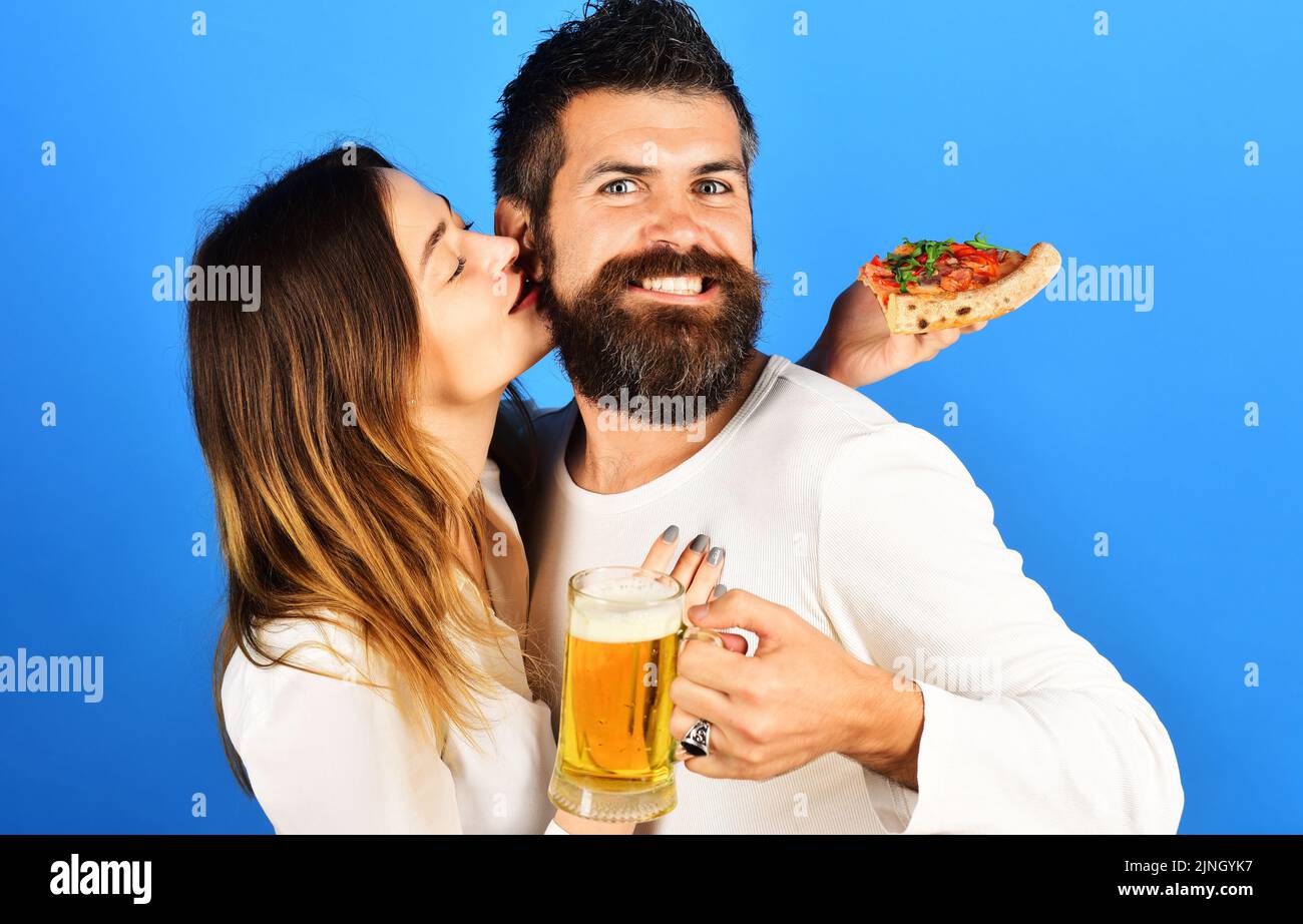 Loving couple eating yummy pizza, drinking beer at pizzeria or pub. Happy family time. Fast food. Stock Photo