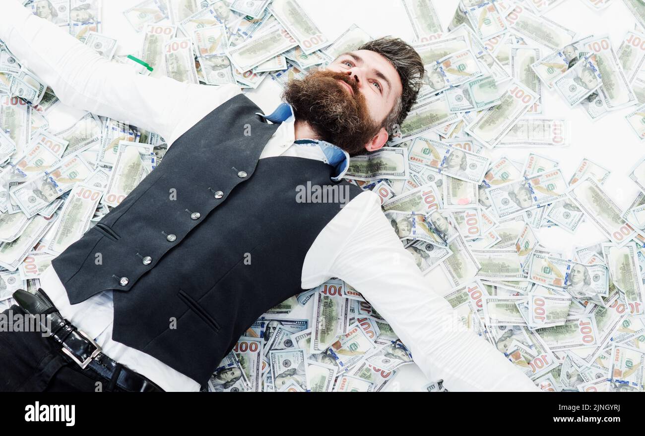 Businessman lying in many banknotes. Saving money. Business success. Rich millionaire, billionaire. Stock Photo