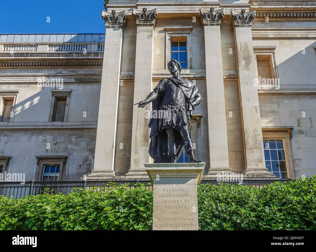 London, UK- July 4, 2022: Trafalgar Square. Jacobus Secundus, James II, statue set in front of green hedge and beige National Gallery facade. Image of Stock Photo