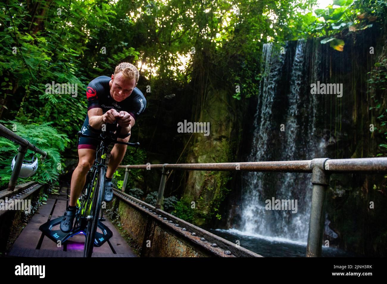 A view of the waterfall with athlete Olaf Van Den Bergh training on his bike. Dutch top athlete Olaf Van Den Bergh starts training in the indoor tropical rainforest of the Burgers' Zoo in Arnhem, in preparation for the Ironman World Championships in Kailua-Kona located in Hawaii. The Bush (indoor tropical rainforest) is the ideal training location because of the high humidity and temperature. (Photo by Ana Fernandez / SOPA Images/Sipa USA) Stock Photo