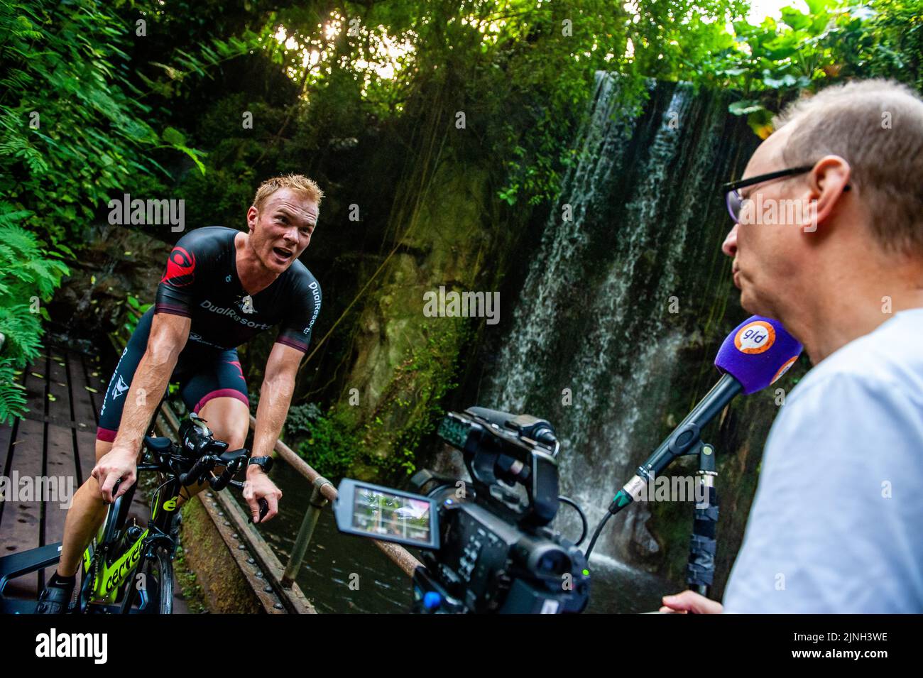 A journalist seen interviewing athlete Olaf Van Den Bergh during his training. Dutch top athlete Olaf Van Den Bergh starts training in the indoor tropical rainforest of the Burgers' Zoo in Arnhem, in preparation for the Ironman World Championships in Kailua-Kona located in Hawaii. The Bush (indoor tropical rainforest) is the ideal training location because of the high humidity and temperature. (Photo by Ana Fernandez / SOPA Images/Sipa USA) Stock Photo