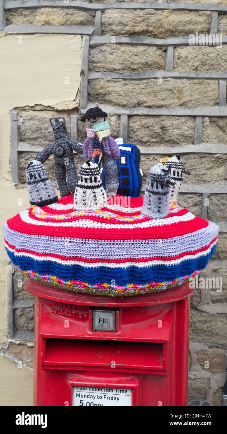 Knitted cover depicting characters from the TV show Dr Who adorns the local postbox at Dobcross in celebration of the Queen's Platinum Jubilee 2022 Stock Photo