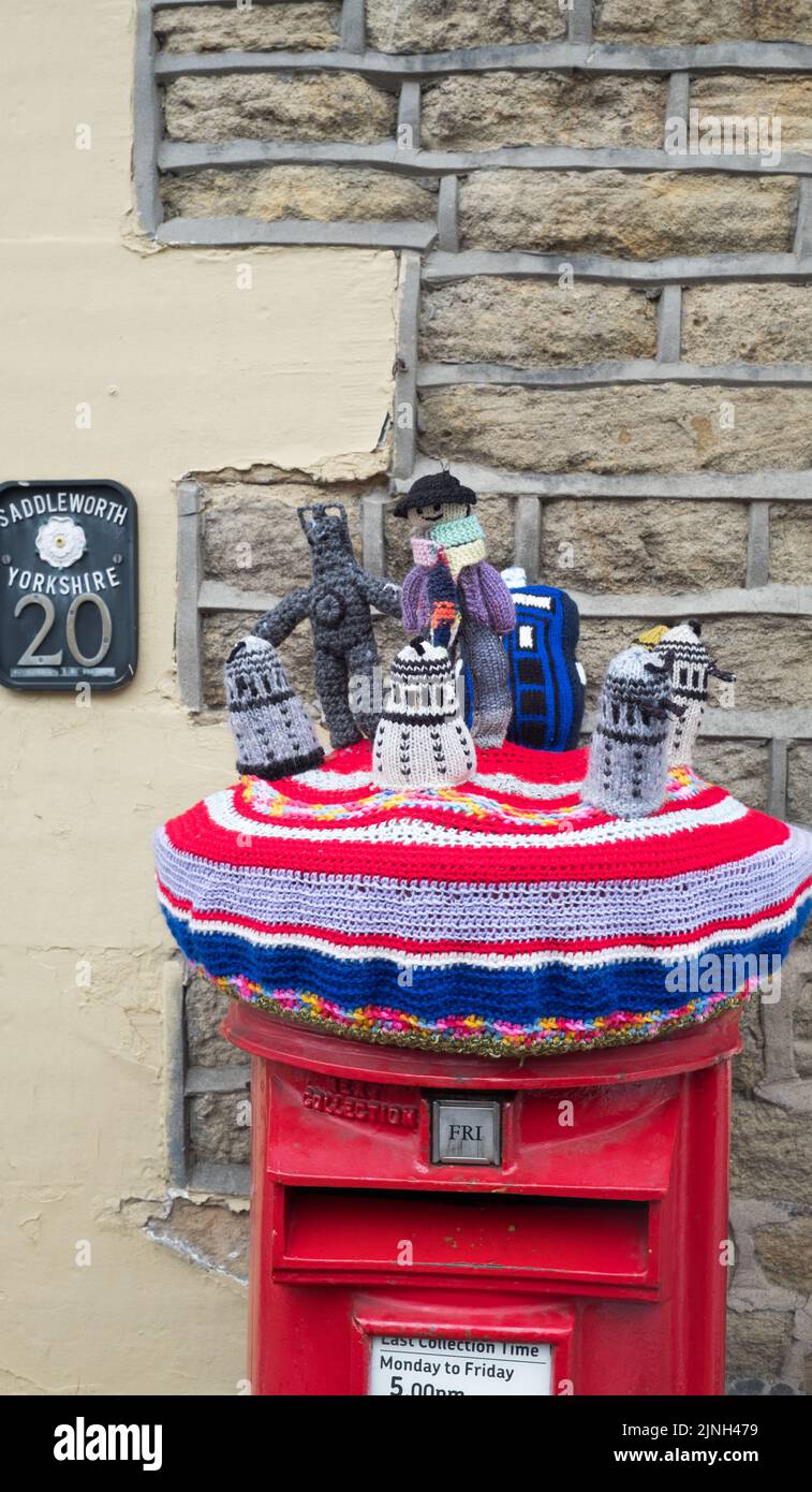 Knitted cover depicting characters from the TV show Dr Who adorns the local postbox at Dobcross in celebration of the Queen's Platinum Jubilee 2022 Stock Photo