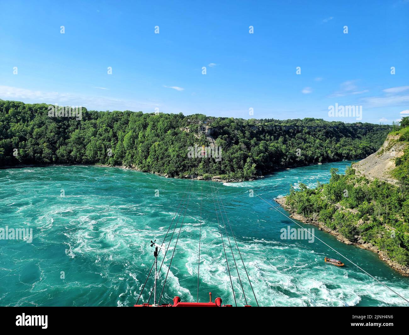 A landscape of the Niagara River Whirlpool surrounded by a green forest