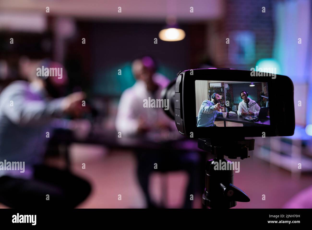Content creator using camera to record podcast conversation, filming ...